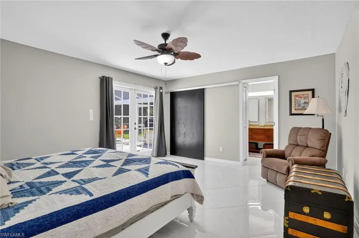 Spacious master bedroom with room darkening curtains that stay, ceiling fan, access to exterior, ensuite bath and 2 separate closets.