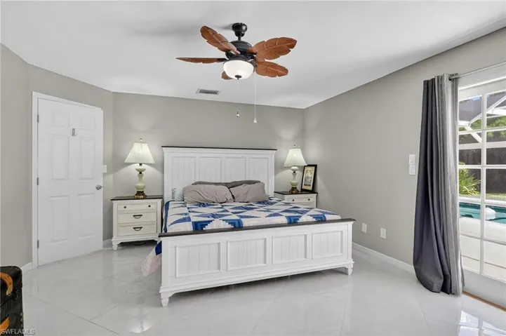 Master bedroom features double french doors leading to pool area.
