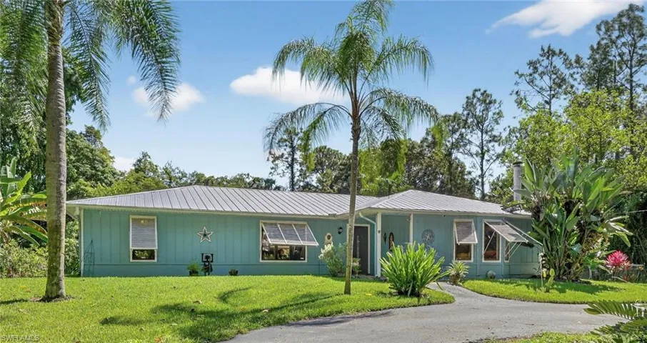 Ranch-style house with a newer metal roof on 2.73 acres with double circle driveway.