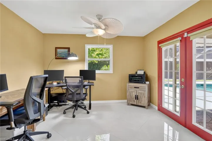 Den/guest room with ceiling fan and double french doors to the pool area.