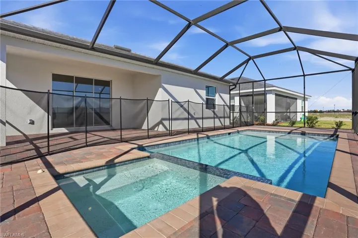 Integrated pool / spa featuring a sunroom, glass enclosure, and a patio