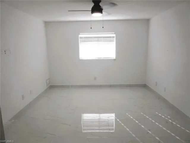 Empty room with a ceiling fan and baseboards