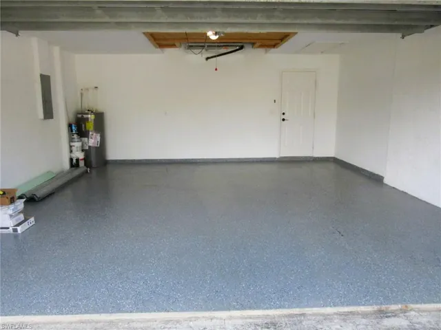 Garage with gas water heater and electric panel