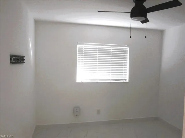 Spare room with ceiling fan and light marble finish flooring