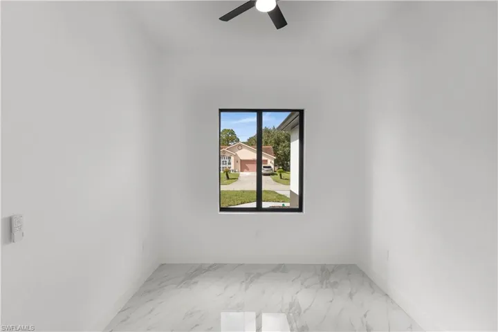 Spare room with light marble finish flooring and baseboards