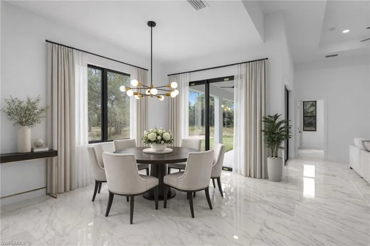 Dining room featuring suspended lighting and light marble finish flooring