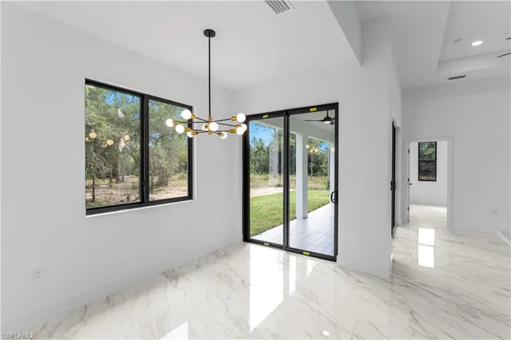 Unfurnished dining area featuring light marble finish floors, a chandelier, and recessed lighting