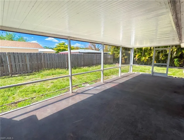 The property features a screened-in patio with a concrete floor and a white paneled ceiling