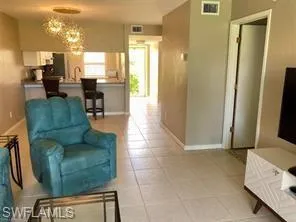 Living room with light tile patterned floors and hanging lights
