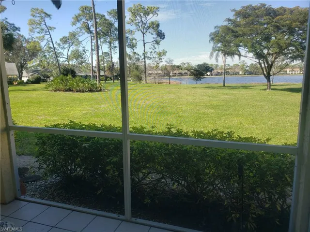 View of grassy yard featuring a water view and a sunroom