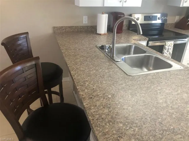 Kitchen with electric range and light tile patterned floors