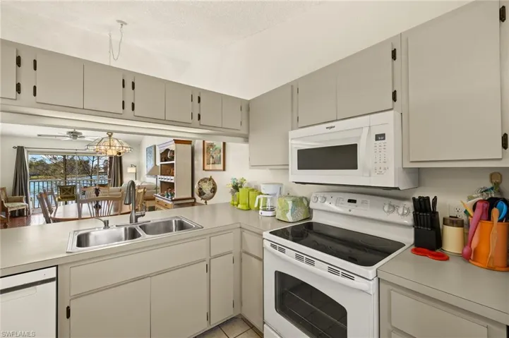 Kitchen featuring white appliances, light countertops, and a sink