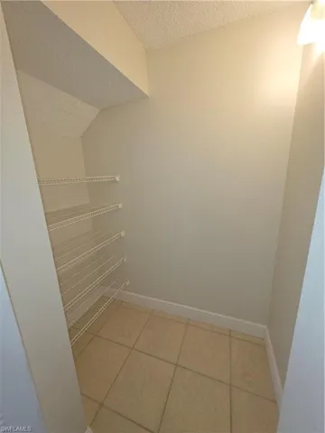 Walk in pantry featuring light tile patterned floors