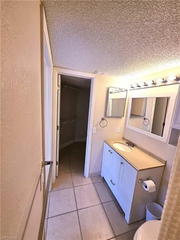 Bathroom with vanity, a textured ceiling, and light tile patterned flooring