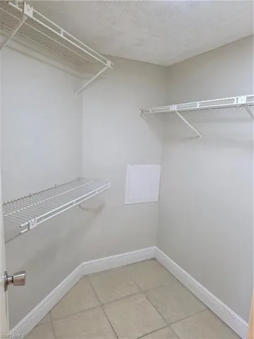 Walk in closet with light tile patterned flooring
