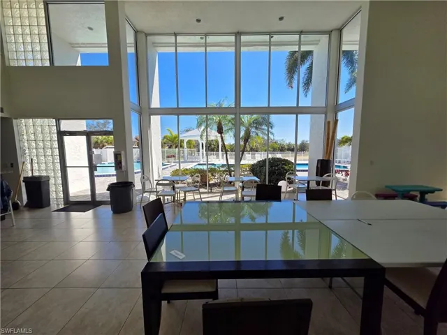 Dining area with a high ceiling, expansive windows, and tile patterned floors