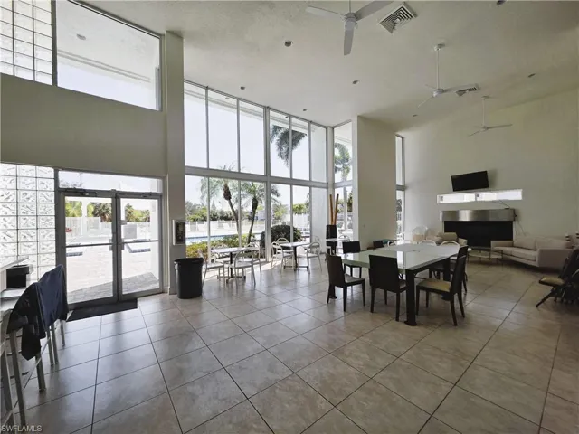 Dining area featuring tile patterned floors, healthy amount of natural light, expansive windows, and a high textured ceiling