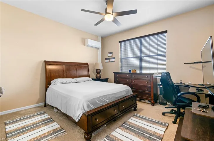 Guest Bedroom 2 featuring light carpet, ceiling fan, and a desk