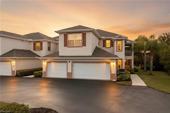 Traditional home with stucco siding, an attached garage, a balcony, and concrete driveway