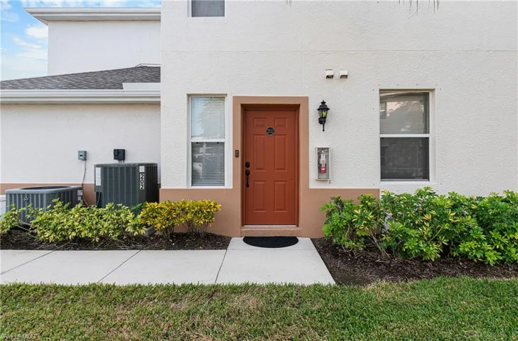 Doorway to property with stucco siding and a lawn