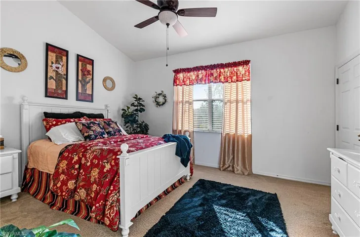 Main Bedroom featuring light carpet, ceiling fan, and lofted ceiling