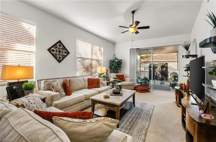Carpeted living room with ceiling fan
