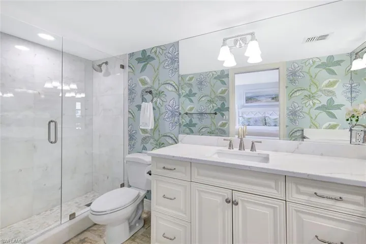 Primary bathroom with a new shower, new quartz countertops and fixtures.