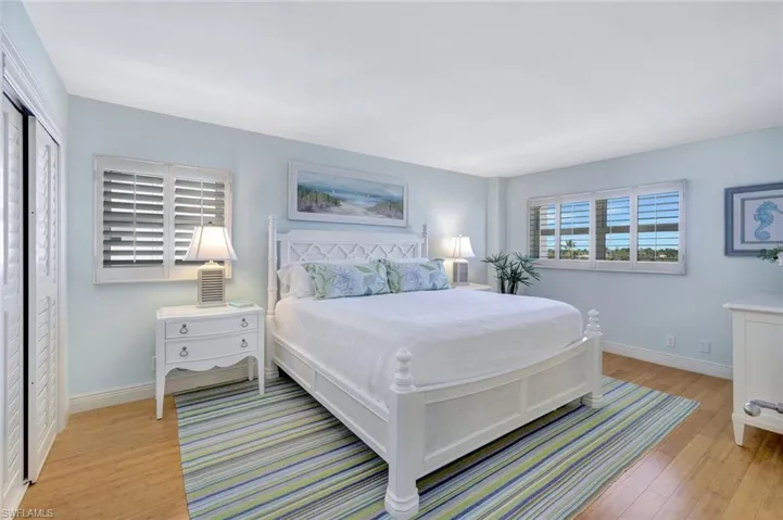 Light and bright primary bedroom with wall of closets.