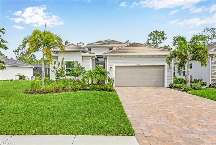 View of front facade featuring a front lawn and a garage