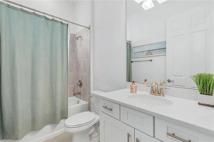 Full bathroom with shower / tub combo, vanity, and toilet