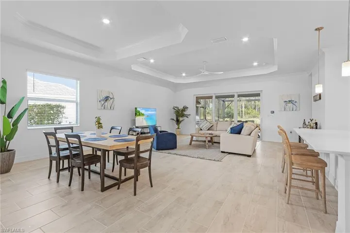 Dining area with ornamental molding, plenty of natural light, and a raised ceiling