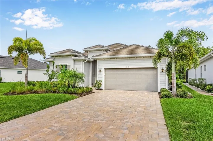 Mediterranean / spanish-style home featuring a front lawn and a garage
