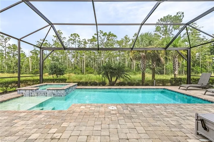 View of pool with an in ground hot tub, a patio area, and a lanai