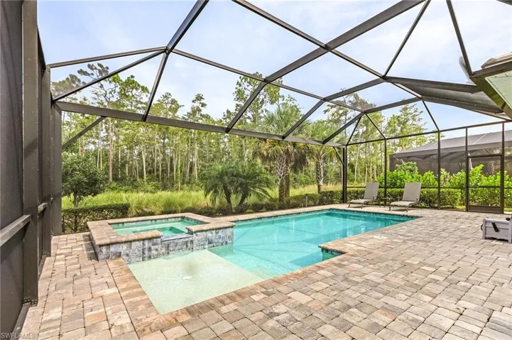 View of swimming pool with an in ground hot tub, a patio area, and a lanai
