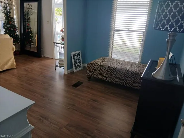 Bedroom featuring access to exterior and dark wood-type flooring