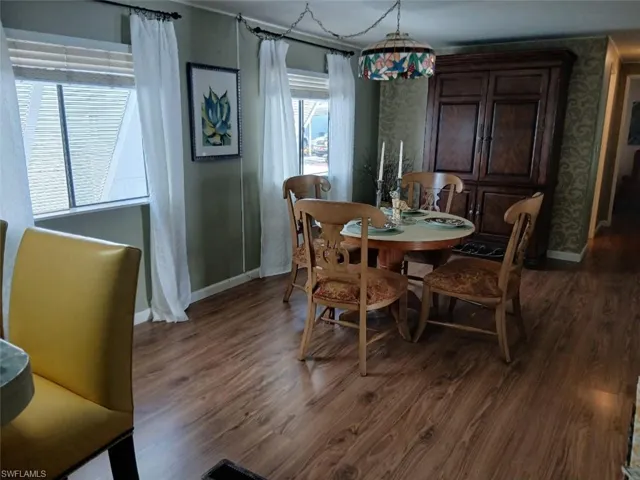 Dining area with dark wood-style floors and baseboards