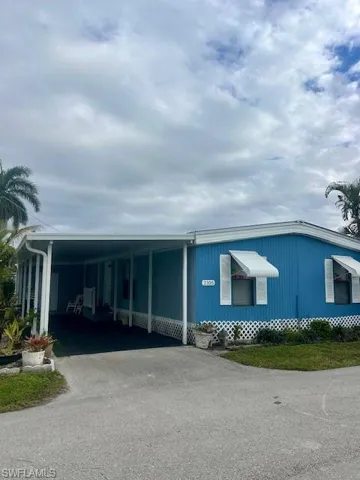 Manufactured / mobile home featuring driveway and an attached carport