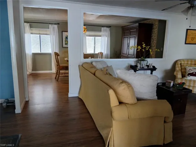 Living area featuring dark wood-style floors and ceiling fan