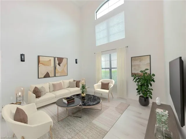 Living room featuring a towering ceiling and light hardwood / wood-style floors