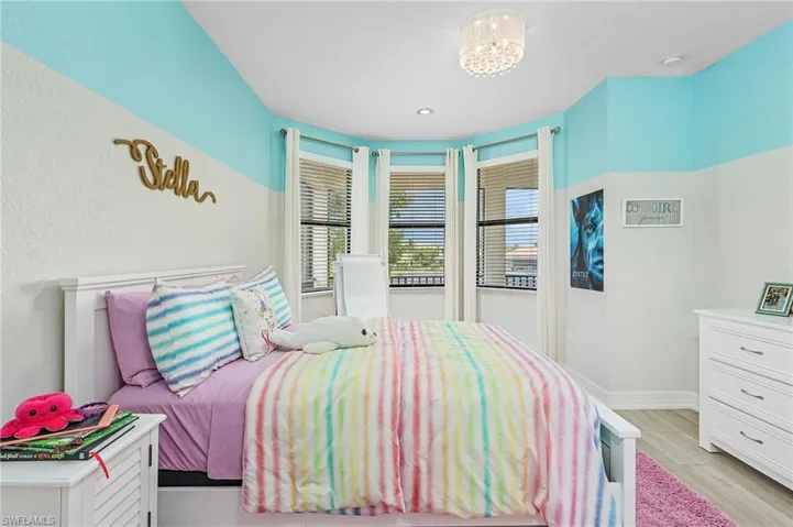 Bedroom featuring light hardwood / wood-style floors and an inviting chandelier