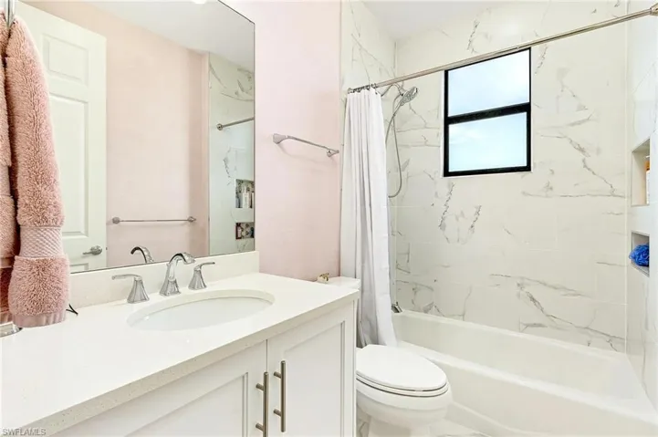 Full bathroom featuring vanity, shower / tub combo, and toilet