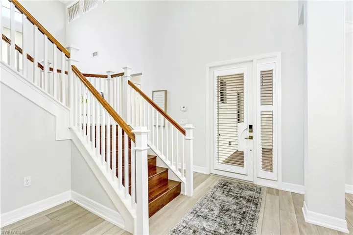 Foyer entrance with a high ceiling and light hardwood / wood-style flooring