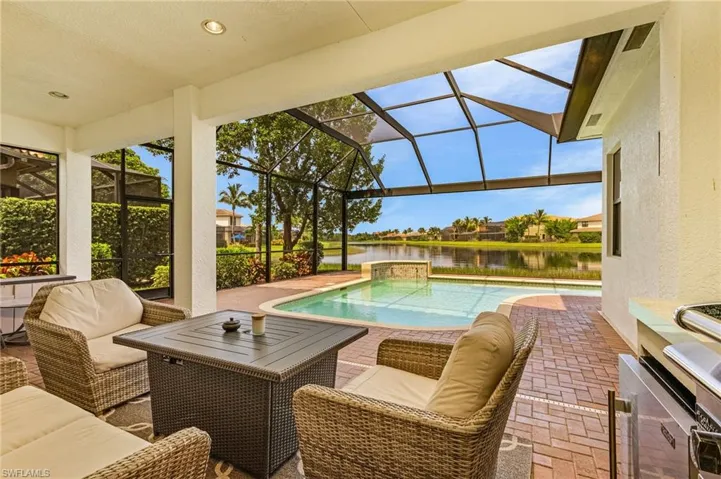 View of swimming pool featuring a lanai, a water view, and a patio area