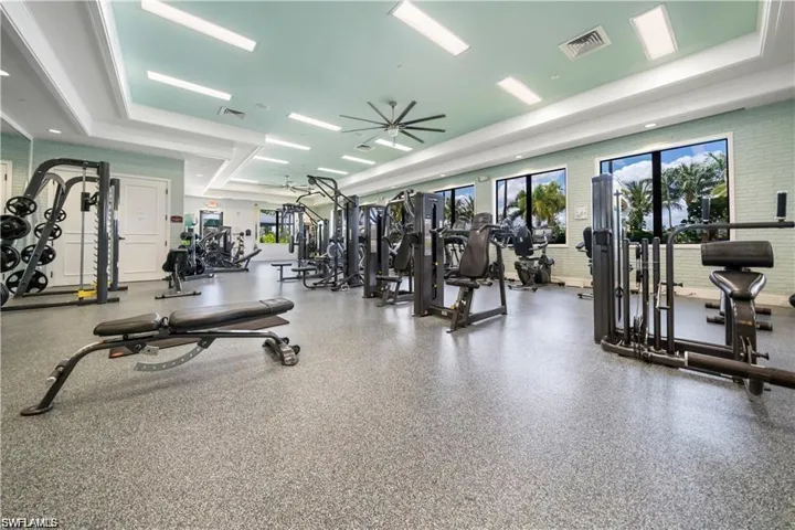 Gym with ceiling fan and a raised ceiling