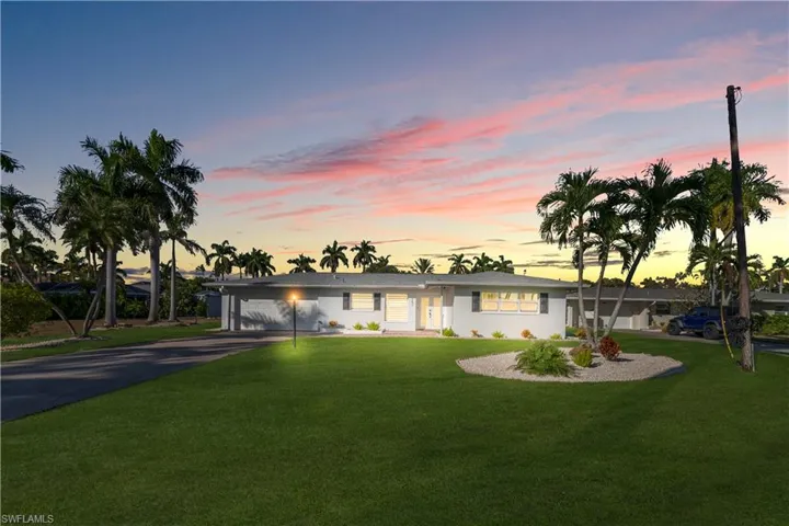 Single story home with driveway, a garage, and a yard