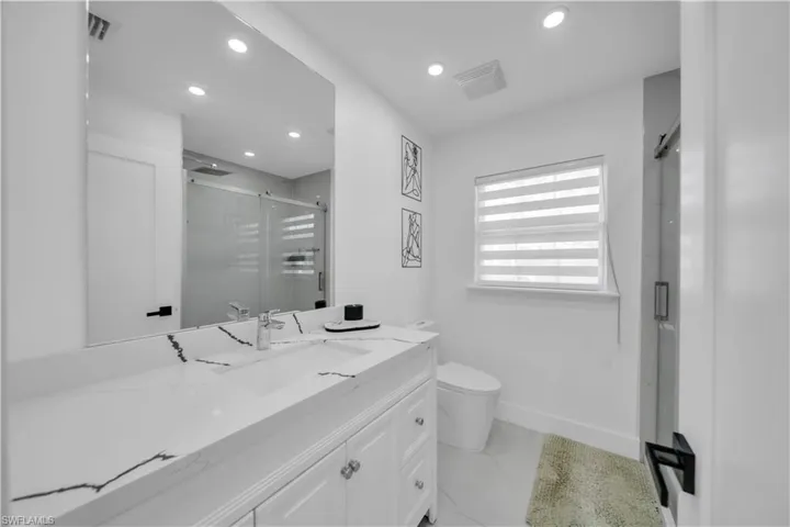 Full bath with a stall shower, vanity, and recessed lighting