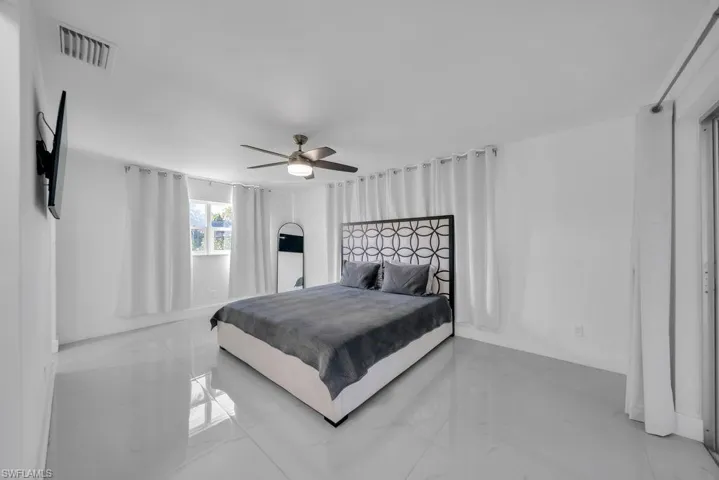 Bedroom featuring ceiling fan and marble tiled flooring
