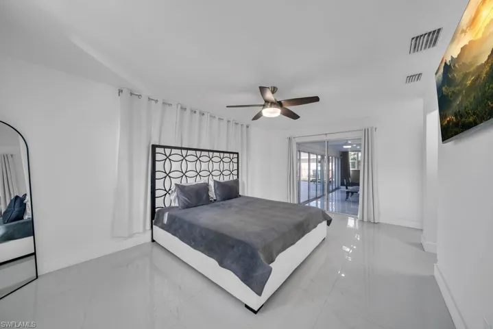 Bedroom featuring access to exterior, marble tiled flooring, and ceiling fan