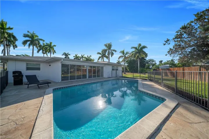 View of swimming pool with patio surround, a fenced backyard, and a grill