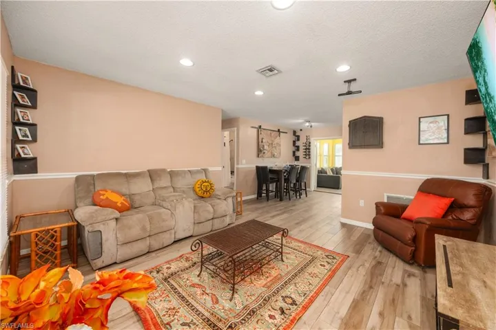 Living room featuring light distressed wood plank tile flooring and soothing warm colors